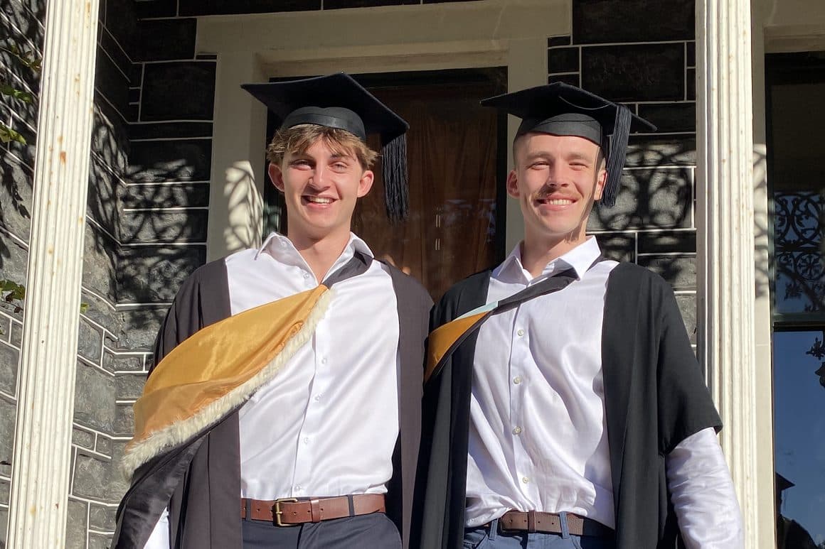 Oscar Salmond and Joe Kelsey in academic gowns and mortarboards on graduation day in Dunedin
